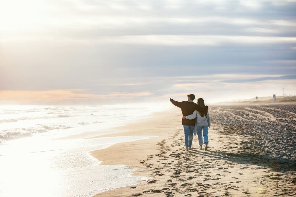 A couple walking on the beach on a Florida winter vacation to Longboat Key.