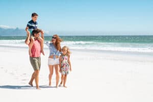 A family on the beach, one of the best things to do on Anna Maria Island in late summer.
